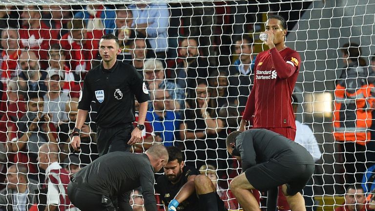 Alisson receives medical attention during Liverpool's match vs Norwich City
