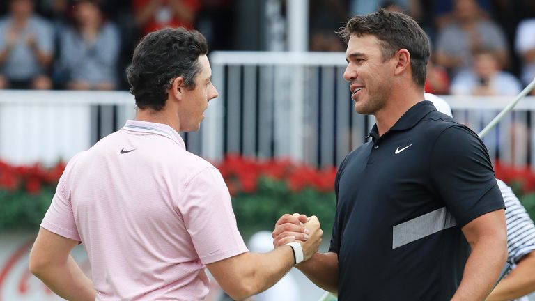 Brooks Koepka of the United States congratulates Rory McIlroy of Northern Ireland on the 18th green after McIlroy won the FedEx Cup and Tour Championship during the final round of the TOUR Championship at East Lake Golf Club on August 25, 2019 in Atlanta, Georgia. 