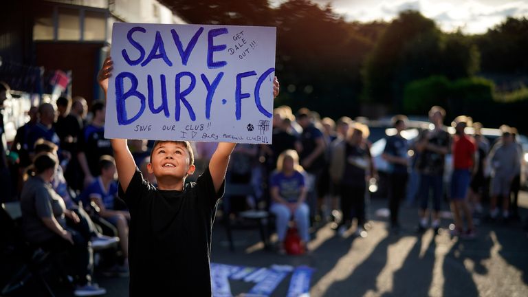Fans chant songs as they stand outside Bury Football Club awaiting a rescue plan
