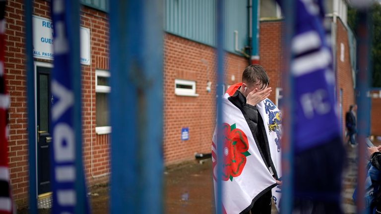 Fans of Bury gather outside Gigg Lane following the club's expulsion from the Football League