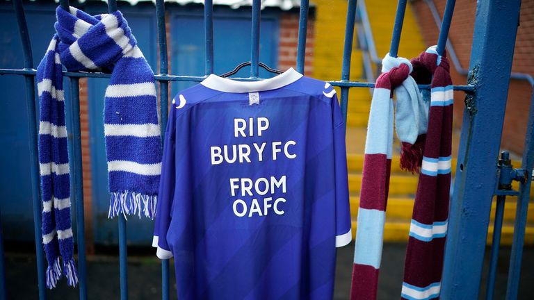 Scarves and a shirt hang from the locked gates of Gigg Lane after Bury's expulsion from the Football League 