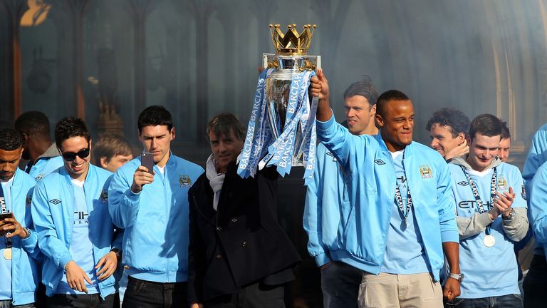 Roberton Mancini and Vincent Kompany of Manchester City lifts the Barclays Premier League trophy in front of Manchester Town Hall before the start of their victory parade around the streets of Manchester on May 14, 2012 in Manchester, England.
