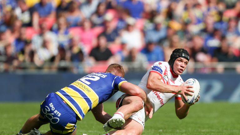 St Helens' Jonny Lomax is tackled by Warrington's Hughes