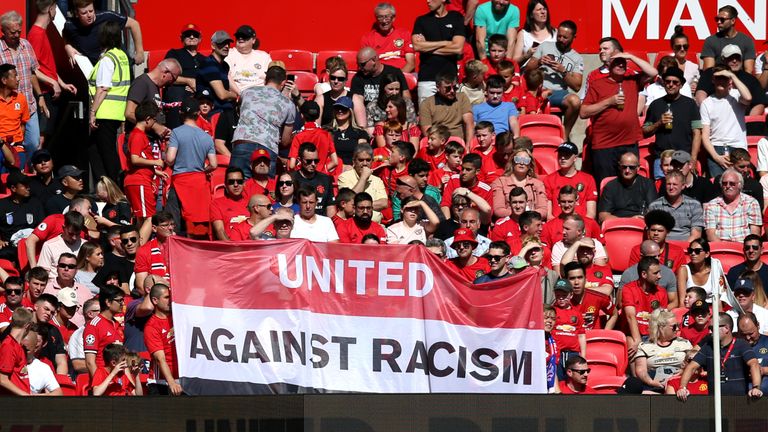 Los fanáticos del Manchester United muestran una pancarta contra el racismo antes del inicio en Old Trafford