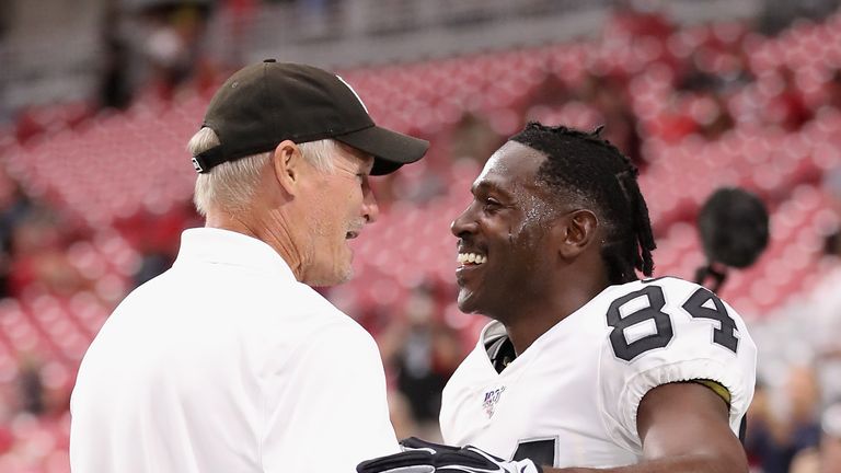 Mike Mayock (L) shares a joke with Antonio Brown