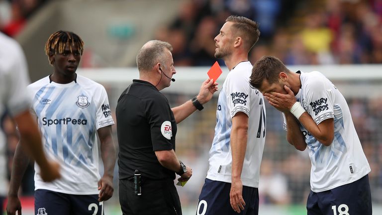 Jonathan Moss shows a red card to Everton's Morgan Schneiderlin 