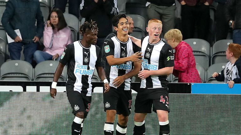 Yoshinori Muto of Newcastle United celebrates after scoring his team's first goal with Matthew Longstaff of Newcastle United (R) and Christian Atsu of Newcastle United (L) during the Carabao Cup Second Round match between Newcastle United and Leicester City at St James' Park on August 28, 2019 in Newcastle upon Tyne, England.