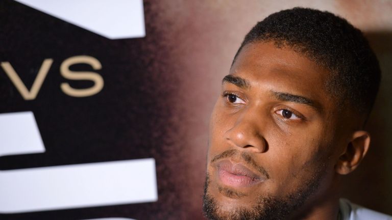 Anthony Joshua poses before a poster of the upcoming &#34;Clash on the Dunes&#34; heavyweight rematch with Andy Ruiz Jr