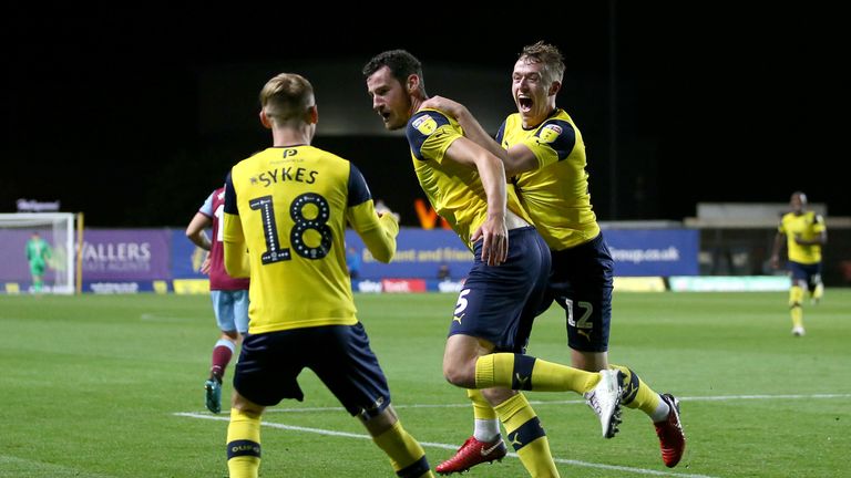 Elliott Moore (centre) celebrates scoring with Oxford United team-mates