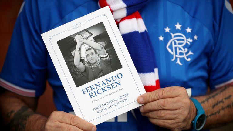 A Rangers fan holds the order of service for Fernando Ricksen's funeral