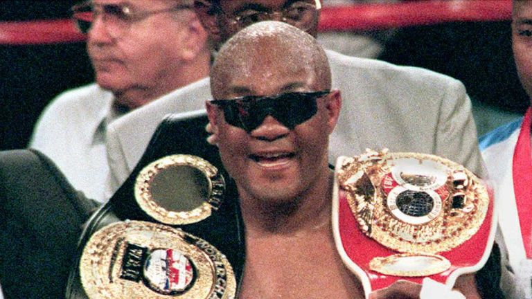 IBF heavyweight champion George Foreman of the US smiles as he holds belts for the International Boxing Federation (IBF) championship and the World Boxing Union (WBU) championship after defeating Axel Schulz of Germany in a 12-round decision at the MGM Grand Garden in Las Vegas 2