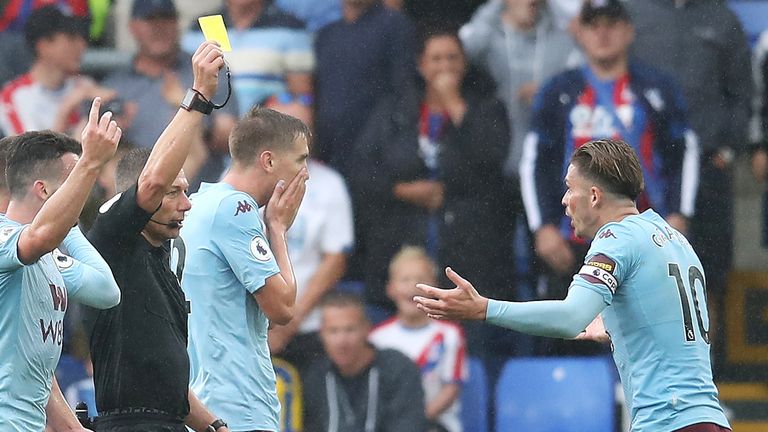 Match referee Kevin Friend gives a yellow card to Jack Grealish of Aston Villa during the Premier League match between Crystal Palace and Aston Villa at Selhurst Park on August 31, 2019 in London, United Kingdom.
