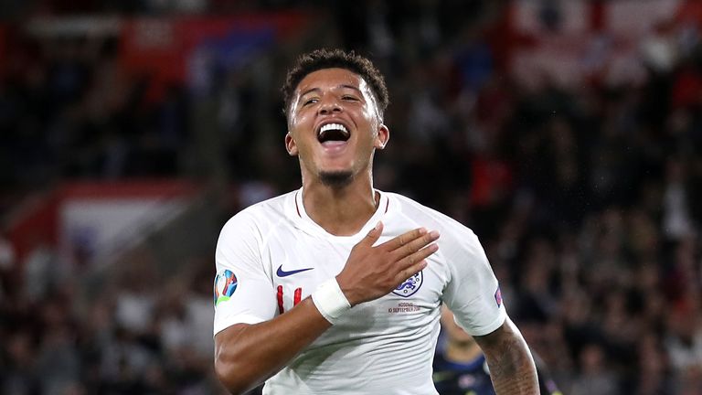 Jadon Sancho pumps the badge on his shirt after scoring England's fourth goal against Kosovo