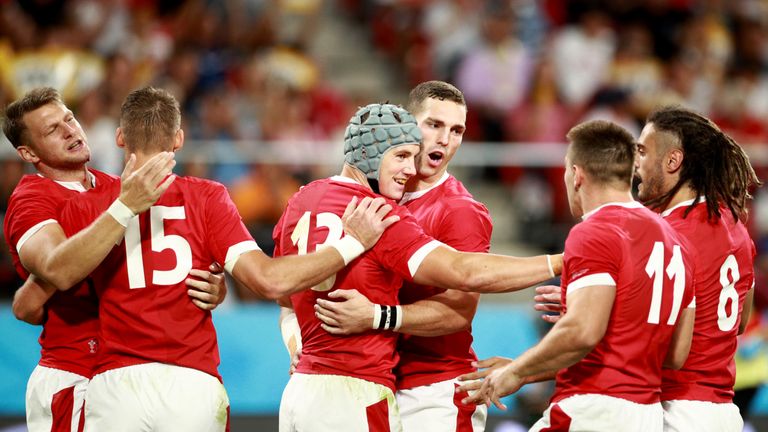 Jonathan Davies celebrates with team-mates after scoring a try for Wales
