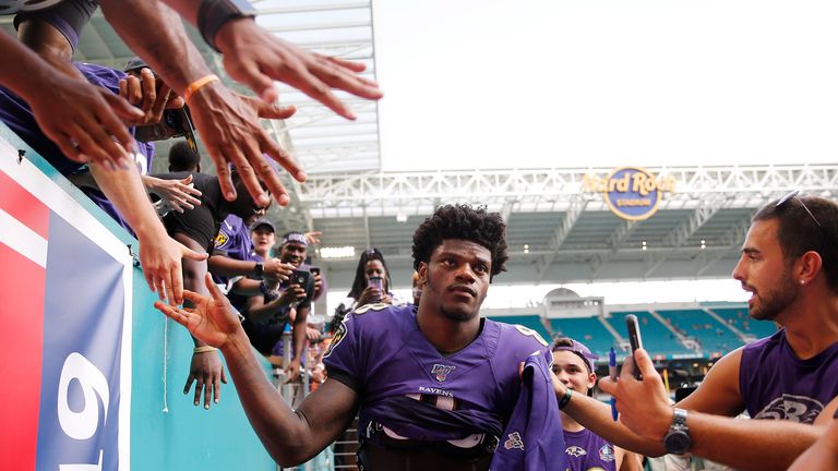 Lamar Jackson of the Baltimore Ravens high fives fans after the game against the Miami Dolphins