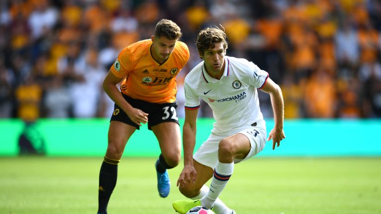 Marcos Alonso runs with the ball under pressure from Leander Dendoncker