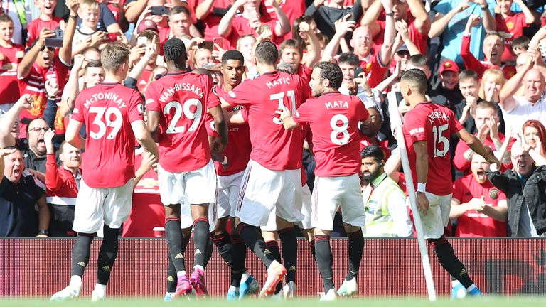 Marcus Rashford celebrates with team-mates after scoring his penalty