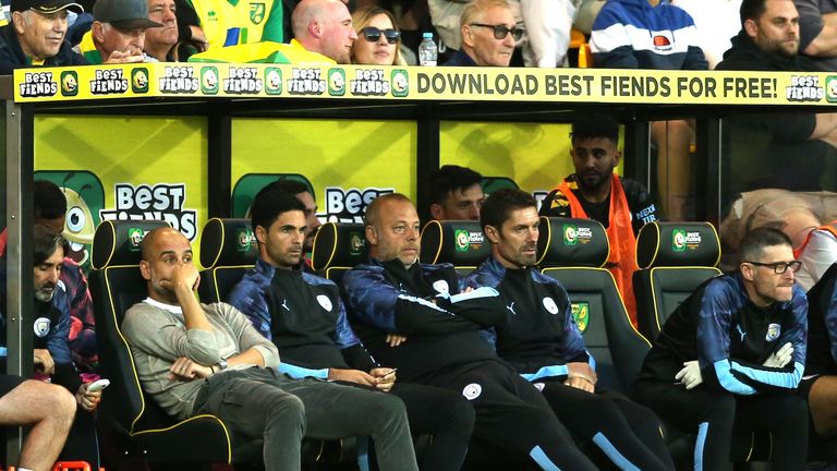 Pep Guardiola and his coaching team look on with Manchester City side trailing 3-1 at Carrow Road