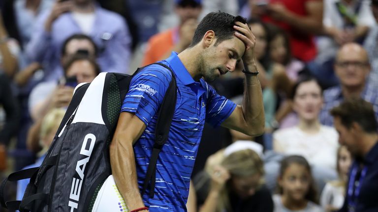 Novak Djokovic of Serbia reacts as he walks off court after retiring due to a shoulder injury during his Men's Singles fourth round match against Stan Wawrink