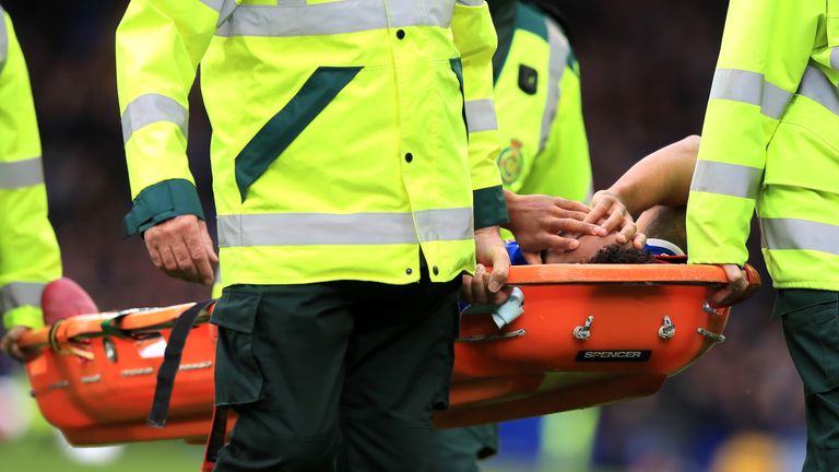 Everton's Theo Walcott is stretched off after being struck by the ball