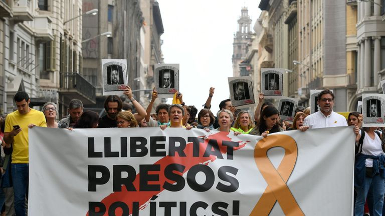 Pro-independence supporters in Barcelona carry a banner reading "Free political prisoners"after their sentencing