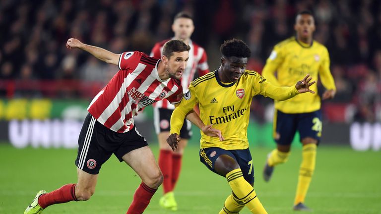 Chris Basham of Sheffield United battles for possession with Bukayo Saka of Arsenal