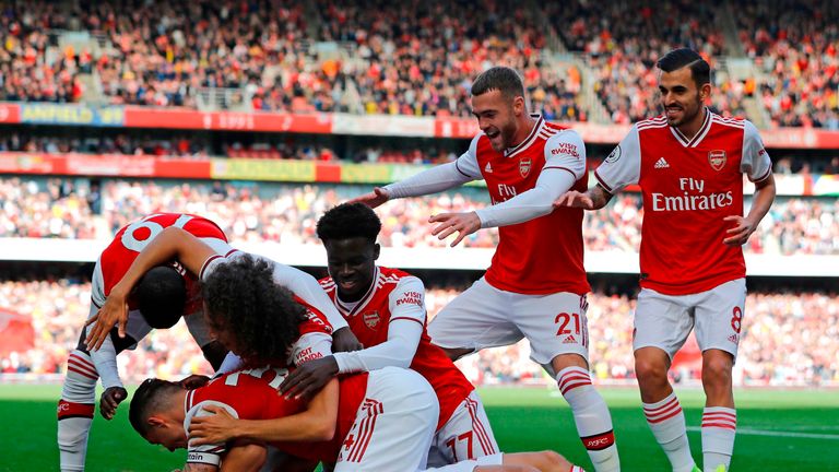 Arsenal players mob Daivd Luiz after he gives them the lead at home to Bournemouth