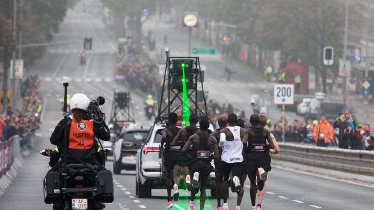 TOPSHOT - Kenya's Eliud Kipchoge (white jersey) takes the start of his attempt to bust the mythical two-hour barrier for the marathon on October 12 2019 in Vienna. - Kipchoge holds the men's world record for the distance with a time of 2hr 01min 39sec, which he set in the flat Berlin marathon on September 16, 2018. He tried in May 2017 to break the two-hour barrier, running on the Monza National Autodrome racing circuit in Italy, failing narrowly in 2hr 00min 25sec. (Photo by ALEX HALADA / AFP) 