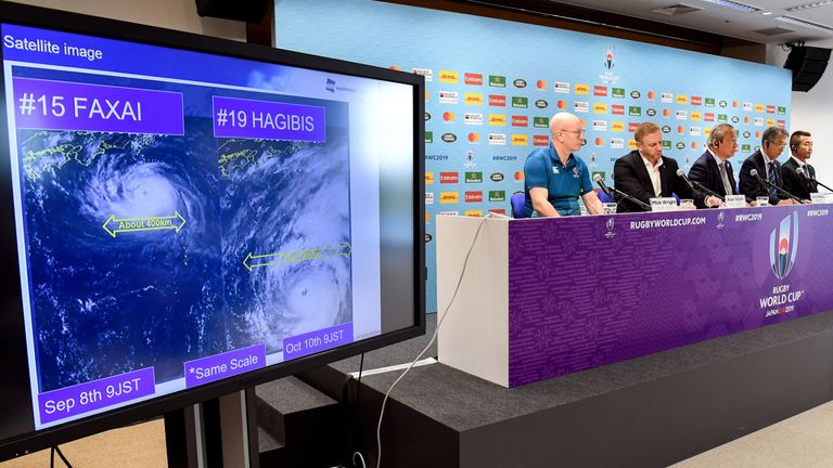 Tournament director of the 2019 Rugby World Cup Alan Gilpin (2nd L) speaks to the media as a screen shows the the path of approaching super typhoon Hagibis