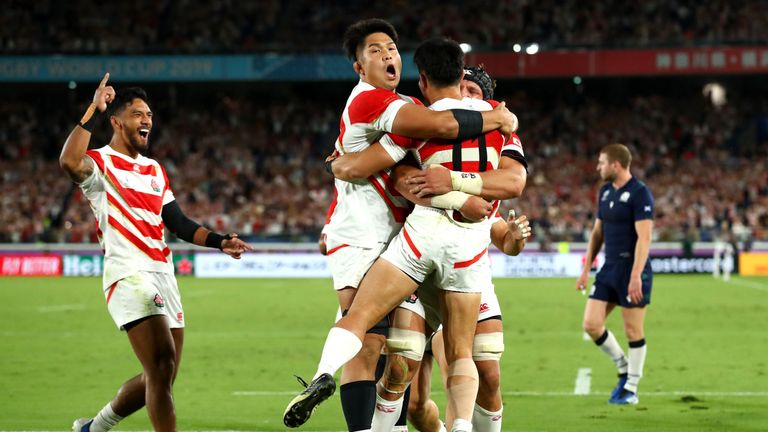 Japan players celebrate their third try of the first half against Scotland