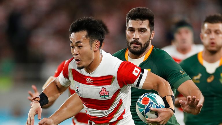 Japan's wing Kenki Fukuoka carries the ball past South Africa's centre Damian De Allende