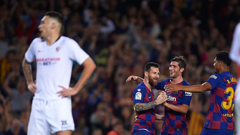 Lionel Messi celebrates with his Barcelona teammates after scoring against Sevilla