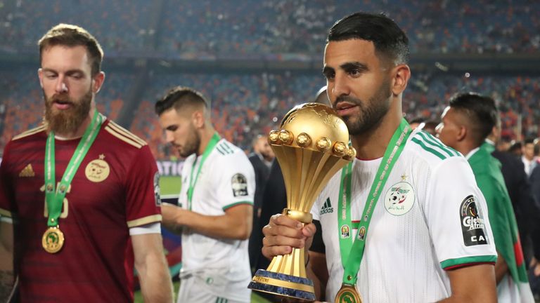 Algeria's forward Riyad Mahrez (R) celebrates with the trophy during the 2019 Africa Cup of Nations (CAN) Final football match between Senegal and Algeria at the Cairo International Stadium in Cairo on July 19, 2019. (Photo by Khaled DESOUKI / AFP) (Photo credit should read KHALED DESOUKI/AFP/Getty Images)