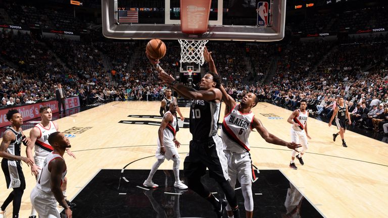 DeMar DeRozan of the San Antonio Spurs twists away from the Portland defense to shoot