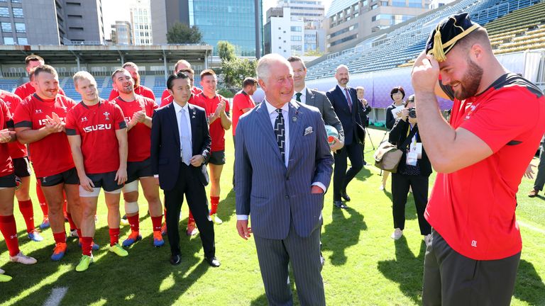 TOKYO, JAPAN - OCTOBER 23: Prince Charles, Prince of Wales presents Owen Lane (R) a cap as he visits the semi-final training venue for the Wales Rugby team at Chichibunomiya Rugby Stadium on October 23, 2019 in Tokyo, Japan. Wales will face South Africa in the semi-final on 27th October. The final will take place on 2nd November.