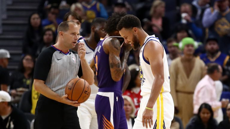 Stephen Curry de los Golden State Warriors hace una mueca después de que se lesionó en la segunda mitad de su juego contra los Phoenix Suns