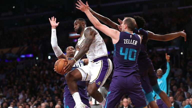 Cody Zeller , Malik Monk and PJ Washington of the Charlotte Hornets attempt to defend against LeBron James of the Los Angeles Lakers