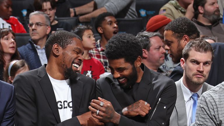Kevin Durant and Kyrie Irving share a joke on the Brooklyn bench