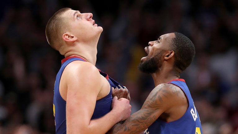 Nikola Jokic es felicitado por su compañero de equipo Will Barton después de golpear a un ganador del partido contra Filadelfia