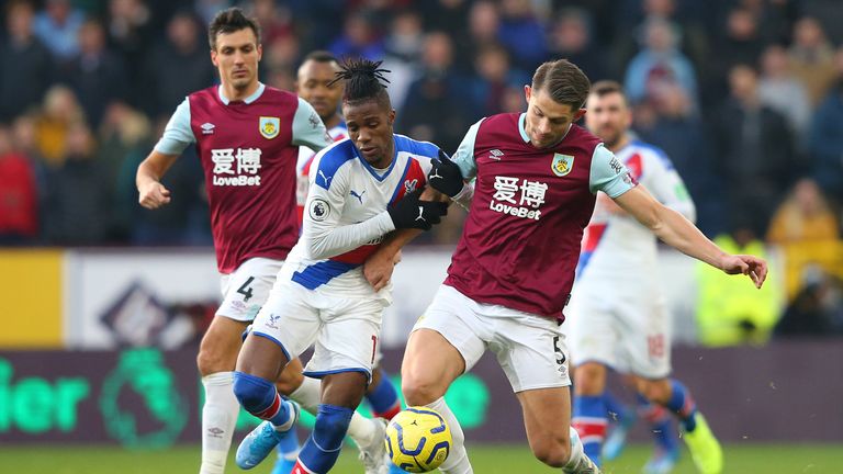 Crystal Palace's Wilfried Zaha challenges for the ball with Burnley's James Tarkowski