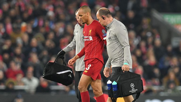 Liverpool's Brazilian midfielder Fabinho (C) leaves the pitch injured during the UEFA Champions league Group E football match between Liverpool and Napoli at Anfield