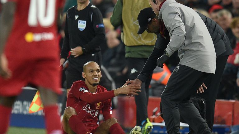 Liverpool's Fabinho prepares to leave the pitch injured against Napoli
