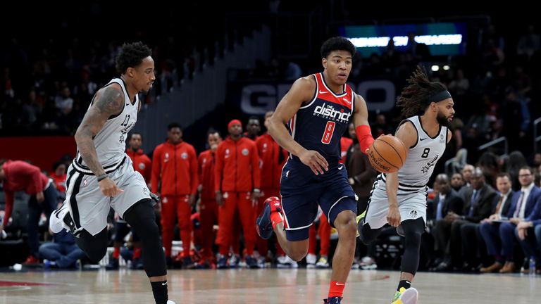 Rui Hachimura of the Washington Wizards dribbles the ball in front of Patty Mills and DeMar DeRozan of the San Antonio Spurs