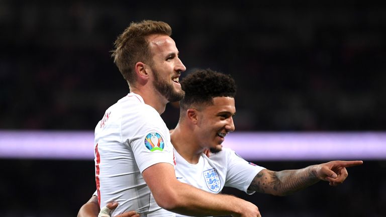 Harry Kane celebrates with Jadon Sancho after scoring his second goal against Montenegro