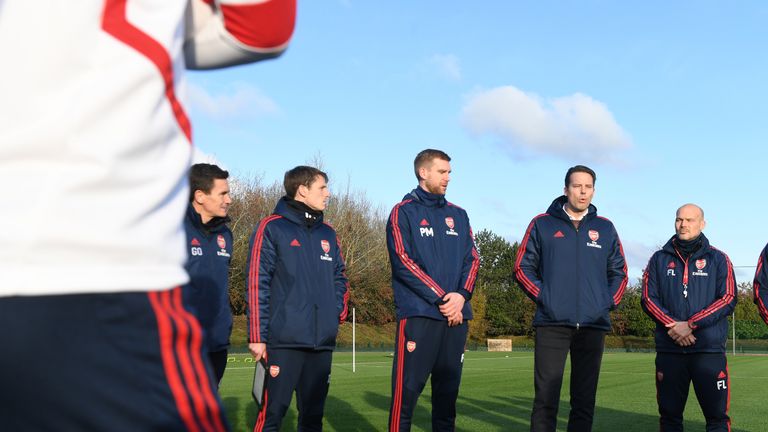 Josh Kroenke (second right) speaks with Arsenal players and coaching staff on Saturday during training