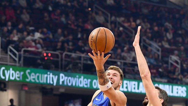Luka Doncic shoots the ball up up over Kevin Love on his way to another triple-double