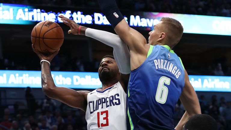 Paul George #13 of the Los Angeles Clippers takes a shot against Kristaps Porzingis #6 of the Dallas Mavericks 