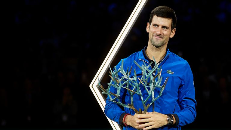 Novak Djokovic celebrates with his trophy after winning the Paris Masters