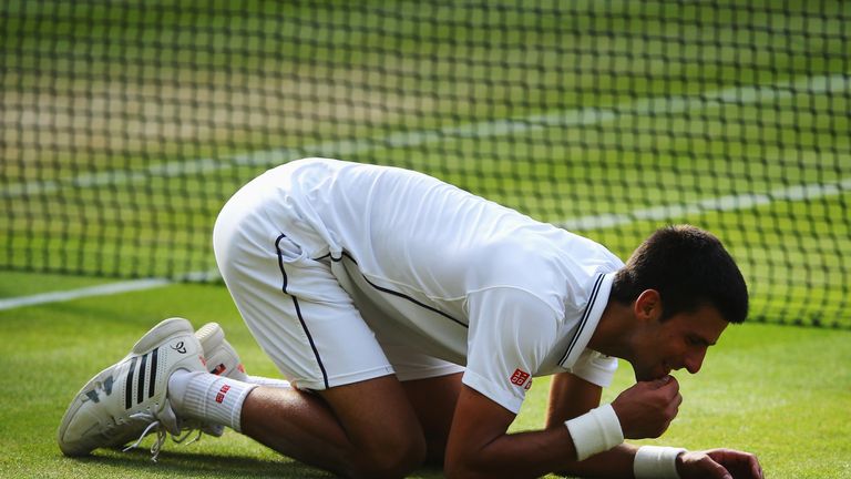 Novak Djokovic of Serbia eats some of the centre court grass as he kneels on the floor as he celebrates winning the Gentlemen's Singles Final match against Roger Federer of Switzerland on day thirteen of the Wimbledon Lawn Tennis Championships at the All England Lawn Tennis and Croquet Club on July 6, 2014 in London, England. 