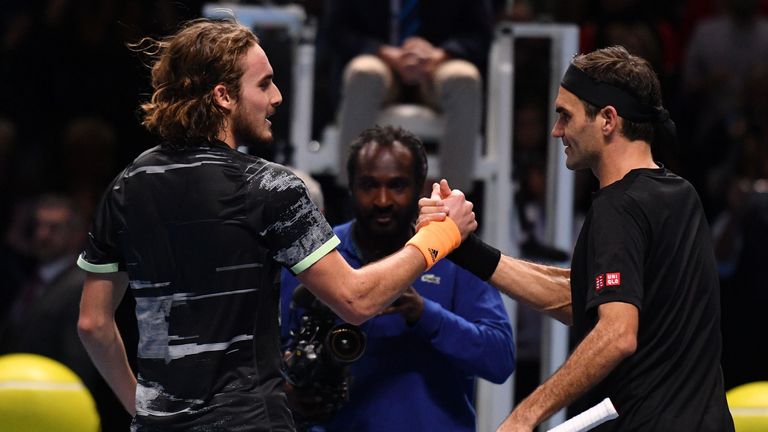 Stefanos Tsitsipas (L) shakes hands as he celebrates victory against Switzerland's Roger Federer (R) during the men's singles semi-final match on day seven of the ATP World Tour Finals tennis tournament at the O2 Arena in London on November 16, 2019.